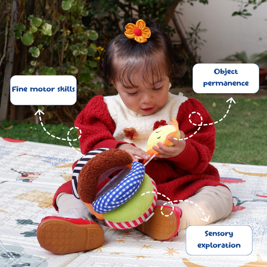Child playing with toys outdoors, highlighting fine motor skills, object permanence, and sensory exploration.