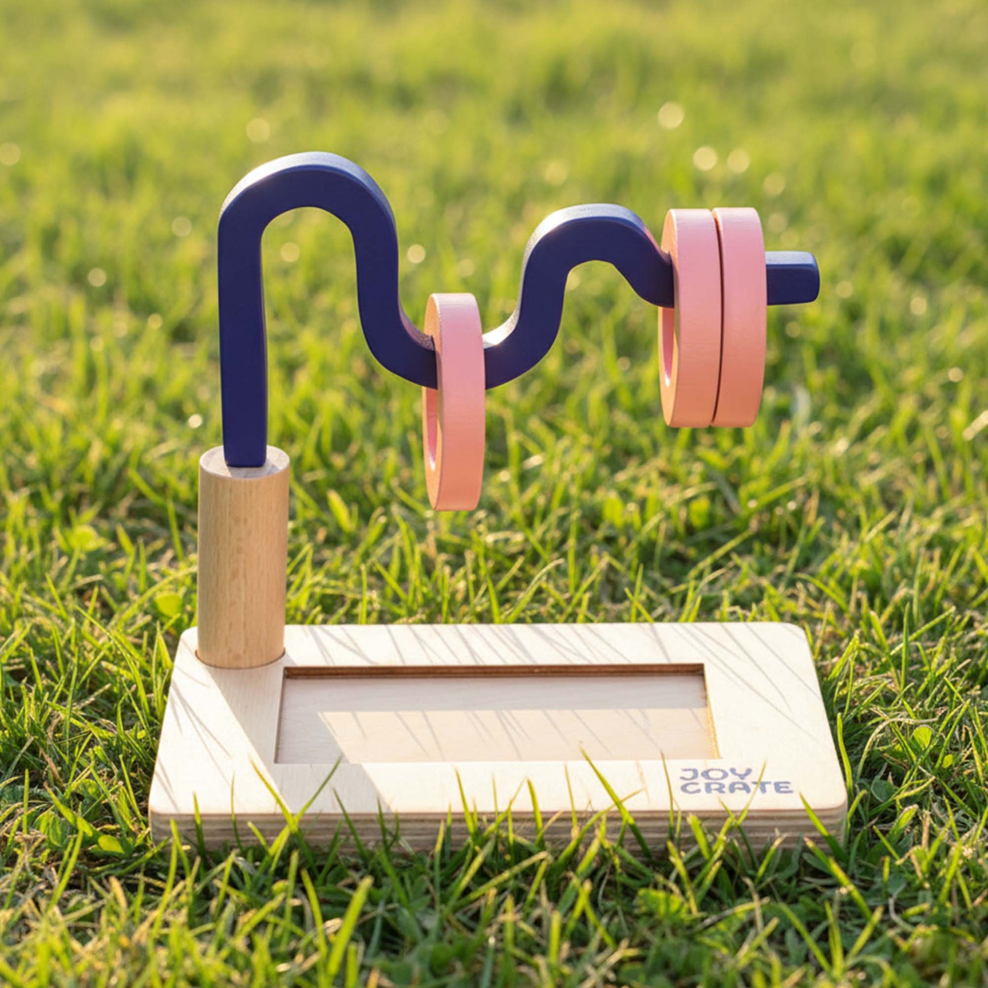 Toy marble run set on grass with 'Joy Crate' branding